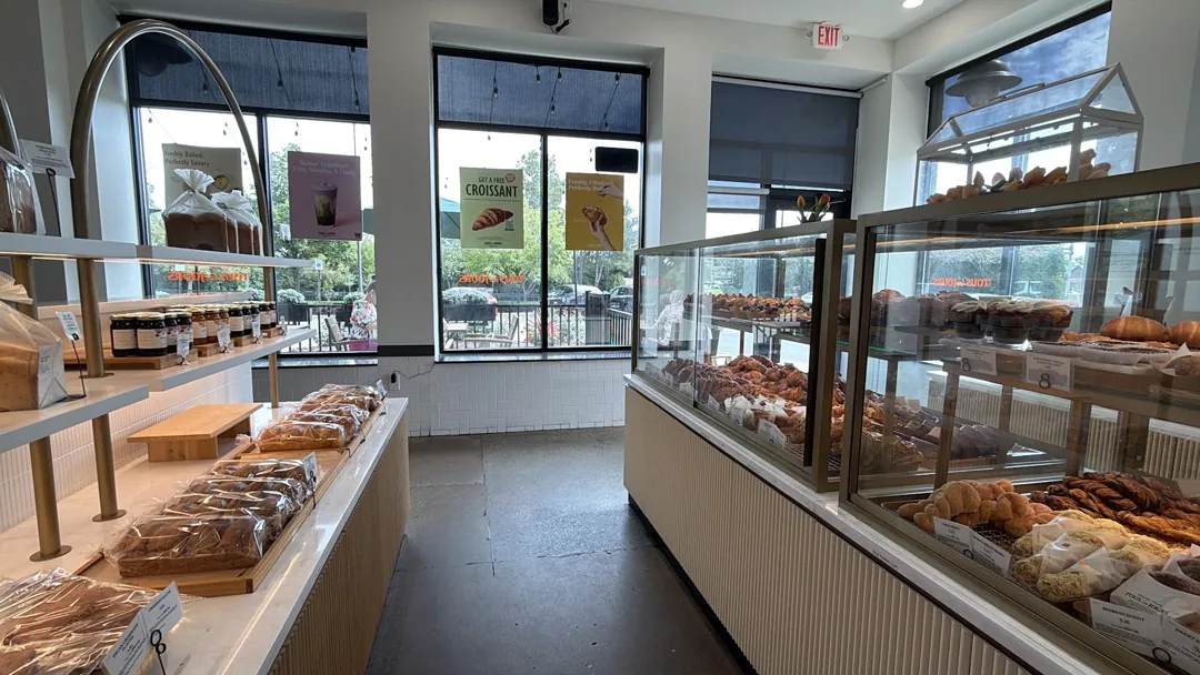 Bakery display cases and tall windows inside TOUS les JOURS Novi